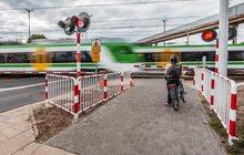 Nowy przejazd kolejowo-drogowy ul. Naczelnikowska w Warszawie, pani na rowerze oczekuje na otwarcie fot. Dawid_Linkowski