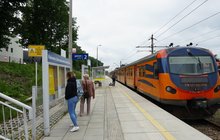 Stacja Kalwaria Zebrzydowska Lanckorona - podróżni na peronie, obok stoi pociąg, fot. Błażej Mstowski