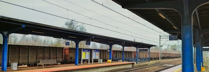 Stacja Pyskowice, peron i widok na tory, w tle pociąg towarowy, fot. Agnieszka Krygler