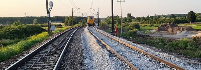 Maszyna podsypuje tłuczeń pod nowy tor na nowym przystanku w Dąbrówce Zabłotniej