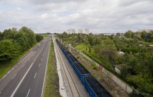 Pociąg towarowy jedzie po nowych torach na szlaku Zabrze Biskupice – Maciejów Północny, obok droga i samochody, fot. Łukasz Hachuła