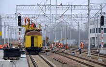 Warszawa Główna, pracownicy na pociągu sieciowym wywieszają nową sieć trakcyjną na torze przy nowym peronie fot. PLK 03.03.2021