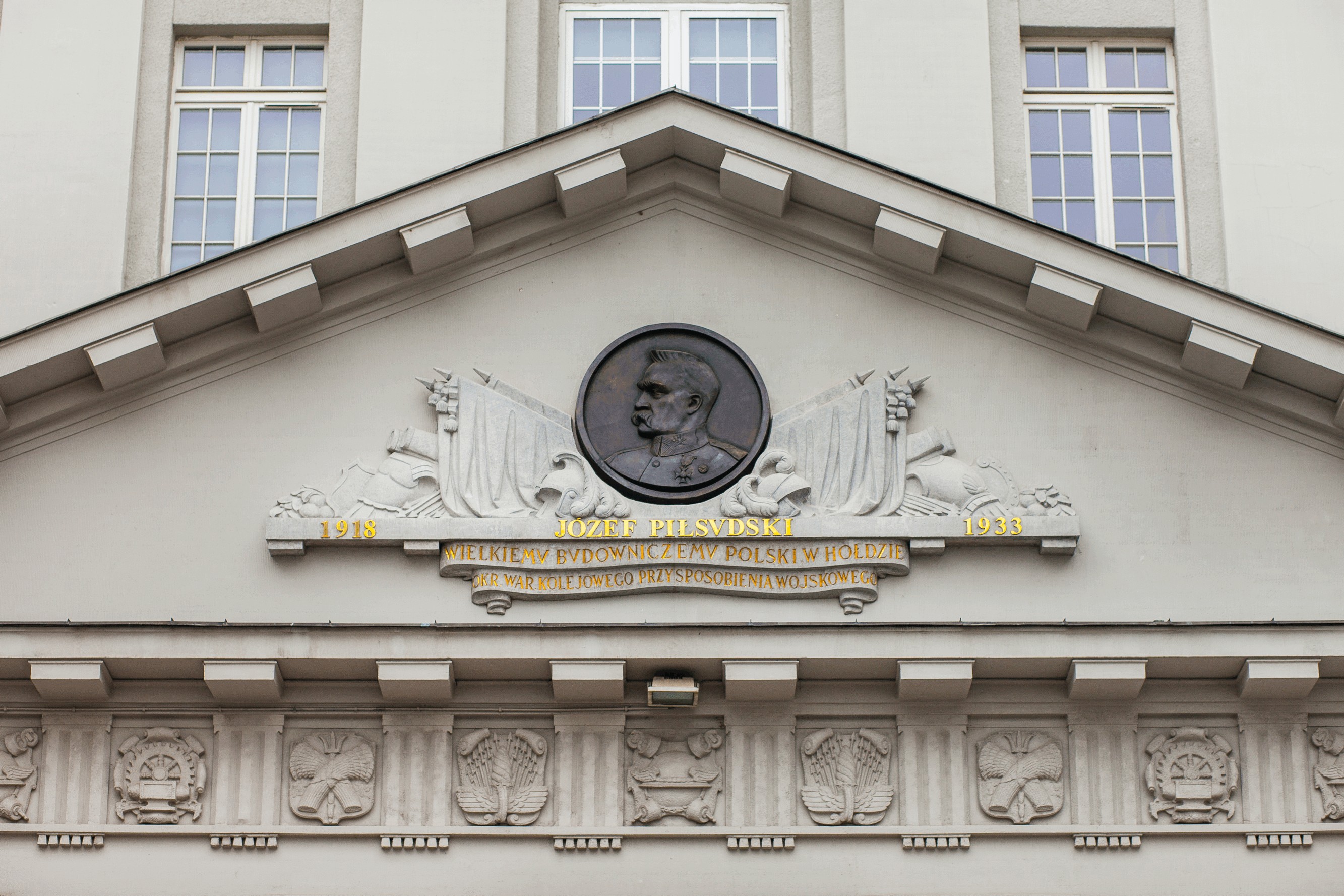 Płaskorzeźba z podobizną J. Piłsudskiego nad głównym wejściem budynku. 