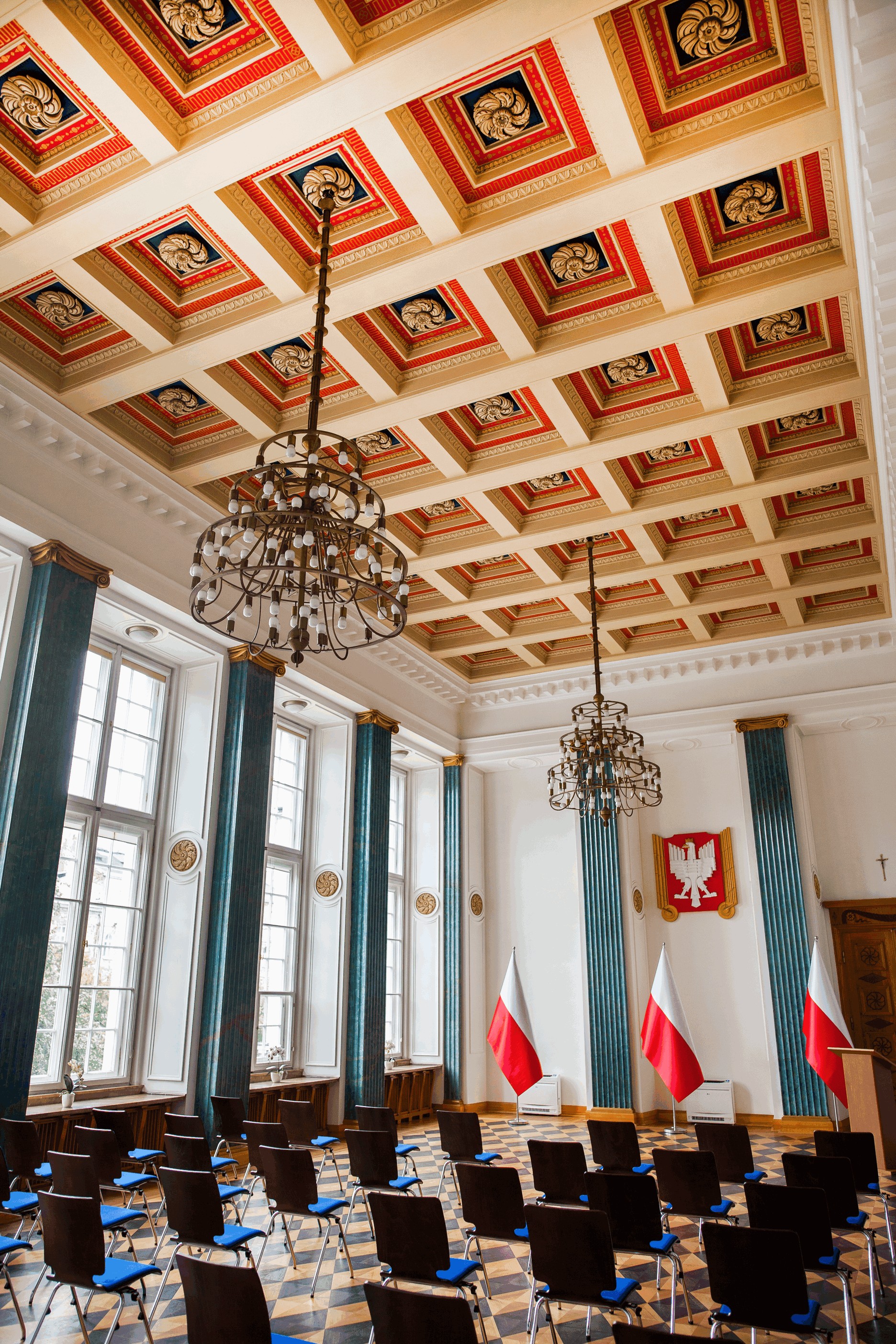 Widok na salę reprezentacyjną przygotowaną na wydarzenie. Widoczny strop kasetonowy.